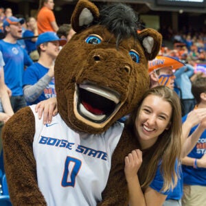 A student and Buster Bronco pose for a photo at a Boise State event