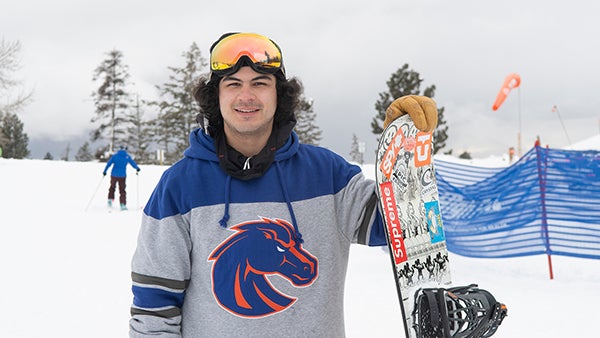 A snowboarder in Boise State attire