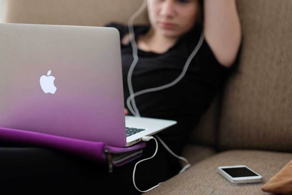 Woman relaxing on a sofa looking at a laptop