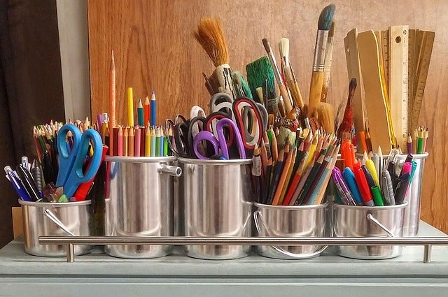 Various art supplies in metal containers
