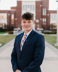 Ethan Mariner standing in front of brick building smiling