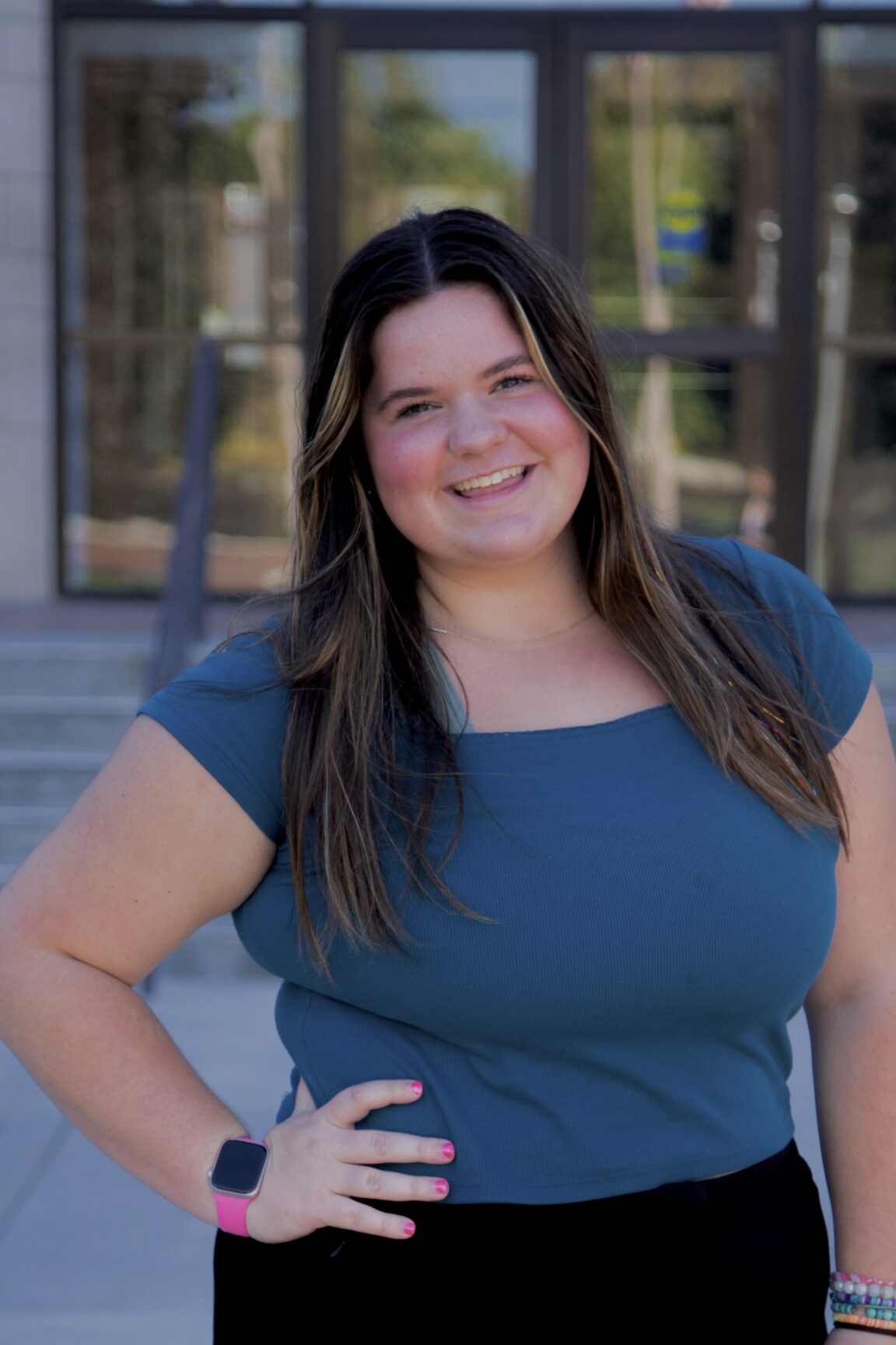 Lauren LaChance stands in front of glass doors, smiling
