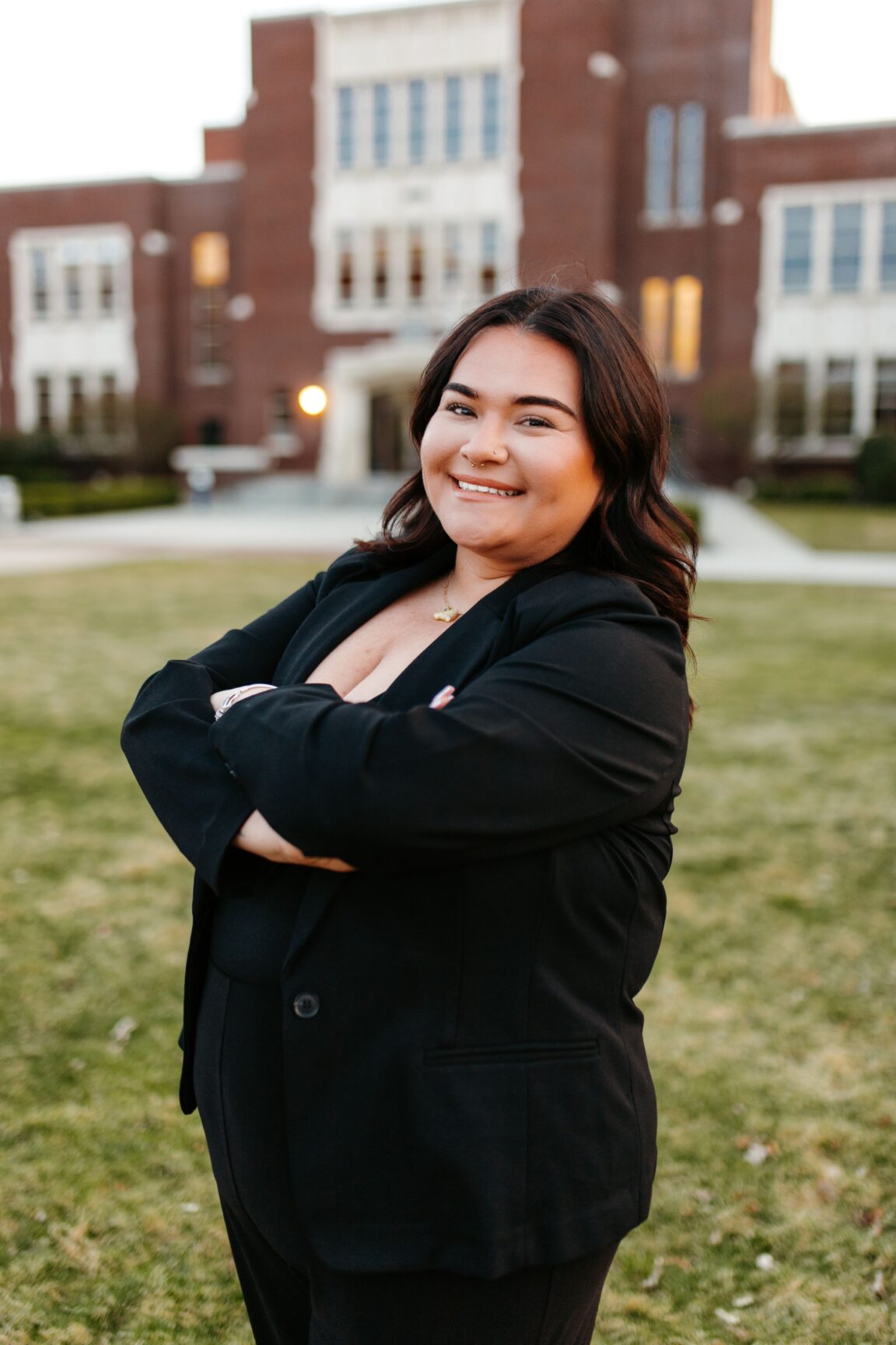 Alyssa Almaraz standing in front of a brick building, smiling