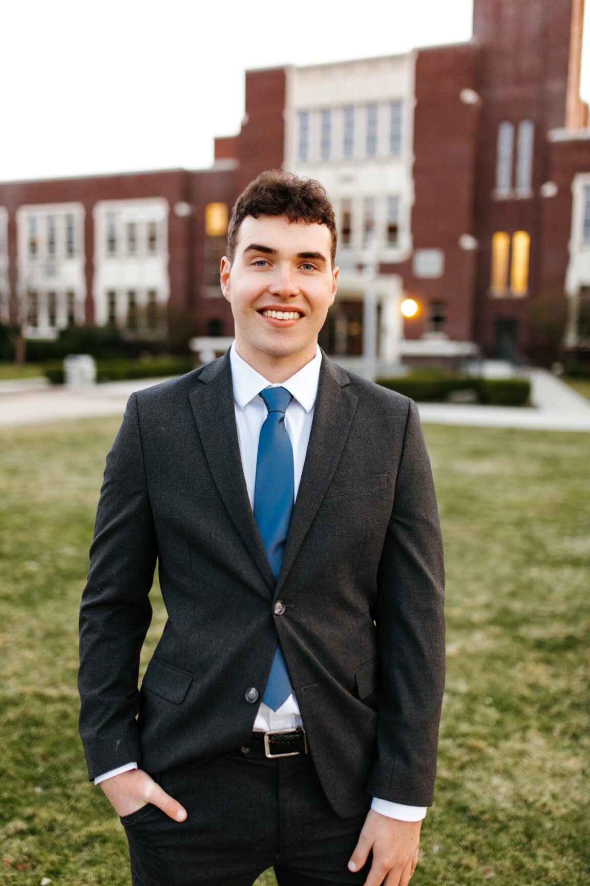 Austin Bearup standing in front of a brick building, smiling