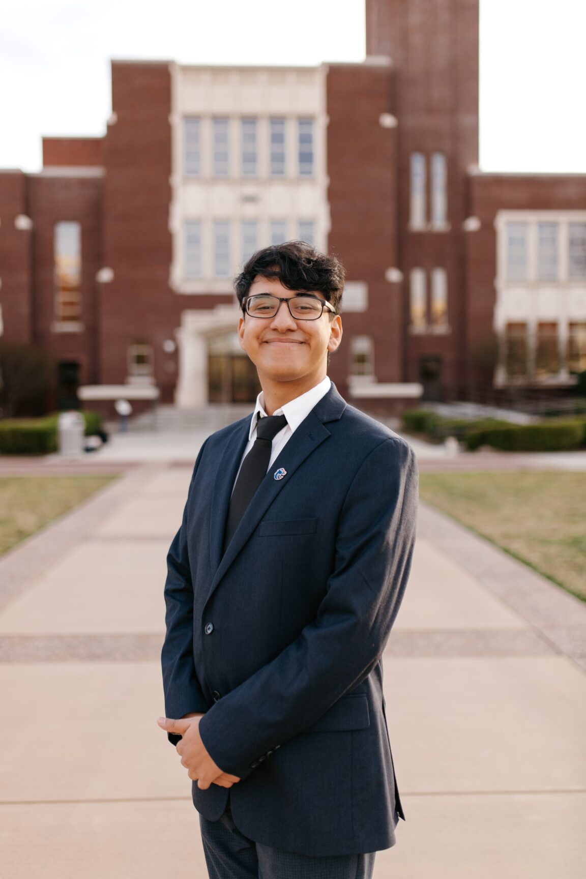 Diego Tapia standing in front of a brick building, smiling