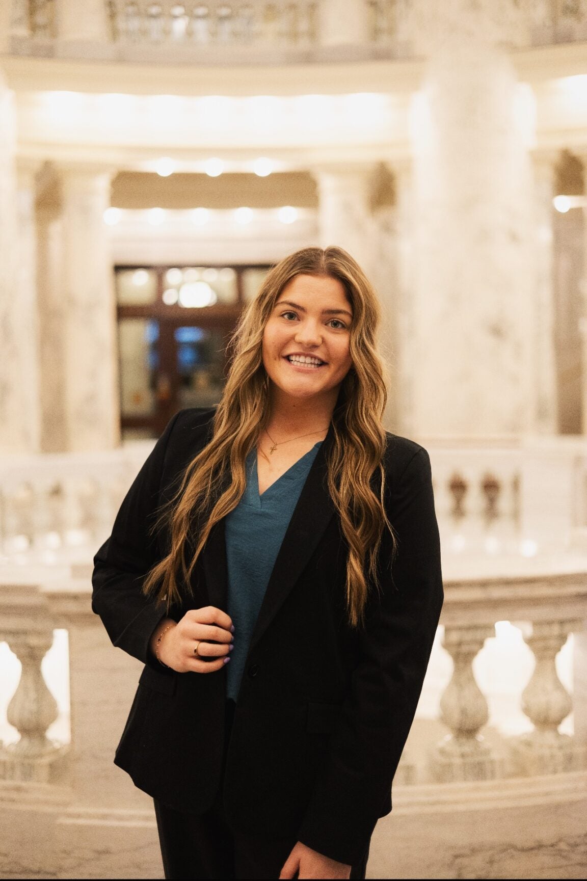 Taylor St. Martin standing in the Idaho Capitol Rotunda, Smiling