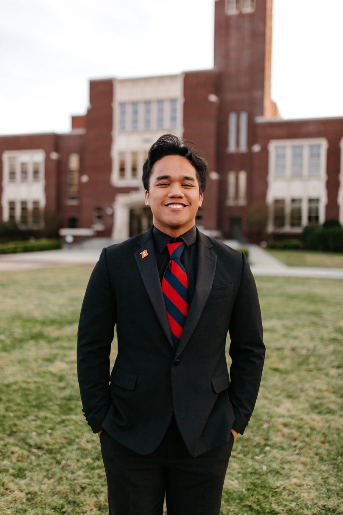 Hiroaki Salas standing in front of a brick building, smiling