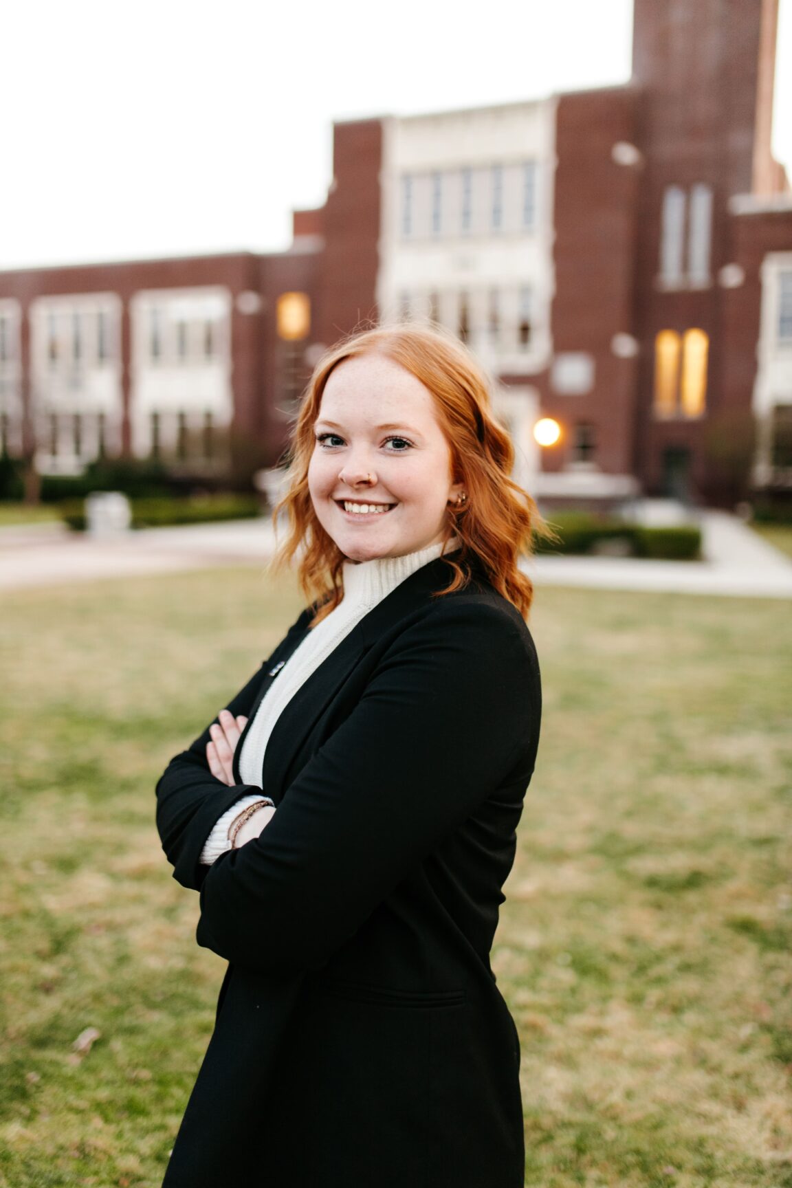K'Lee Burbank standing in front of a brick building, smiling