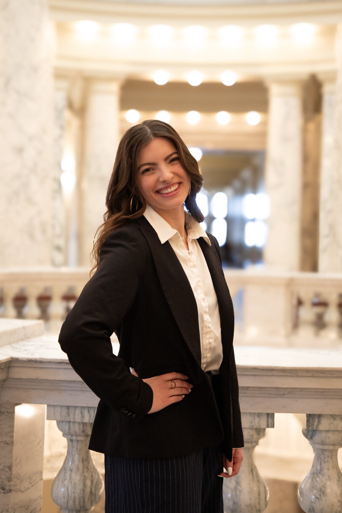 Chloe Conklin standing in the Idaho Capitol Rotunda, with her hand on her hip, smiling