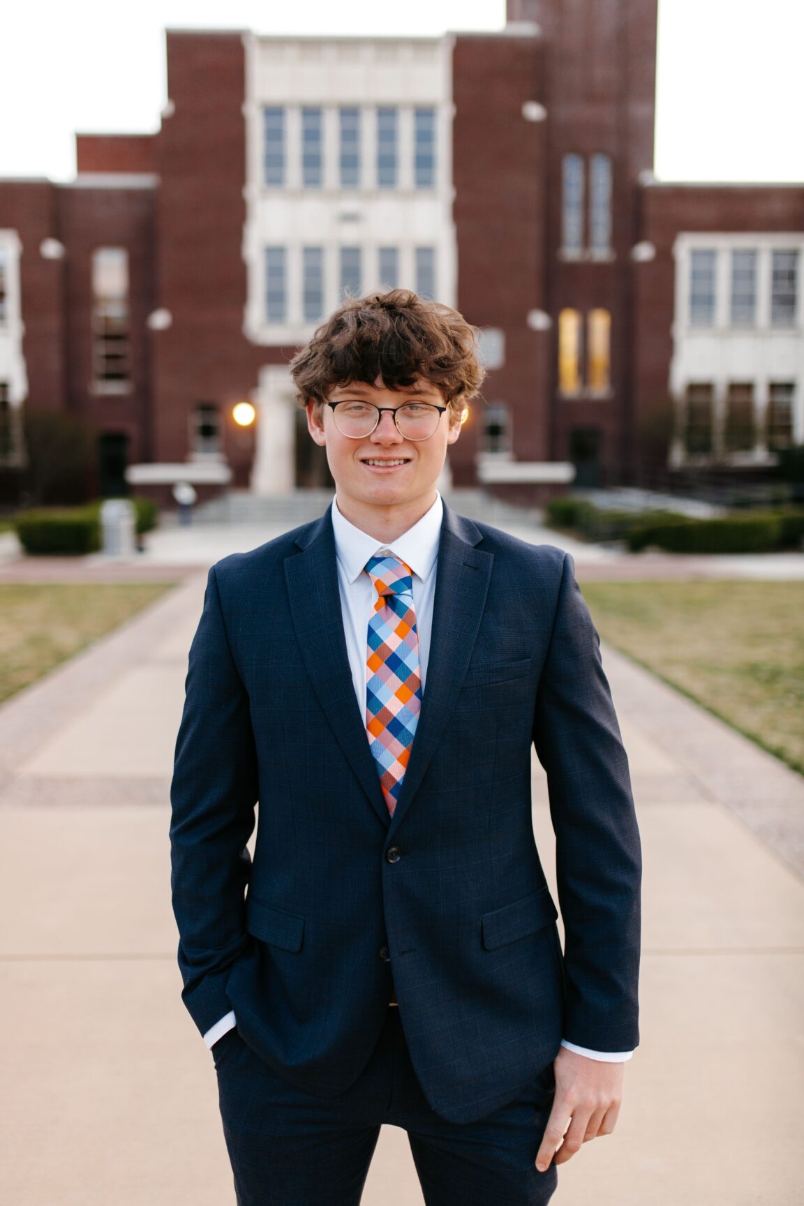 Ethan Mariner standing in front of a brick building, smiling