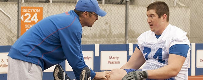 Athletic trainer assesses football player