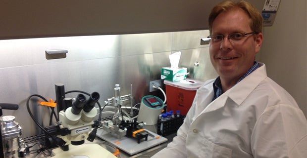 Brad Morrison smiling with hood and microscope in background
