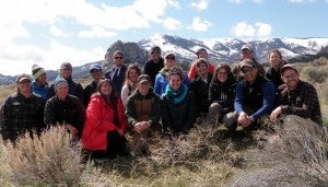 Field crew pose for group photo with blue sky in the background