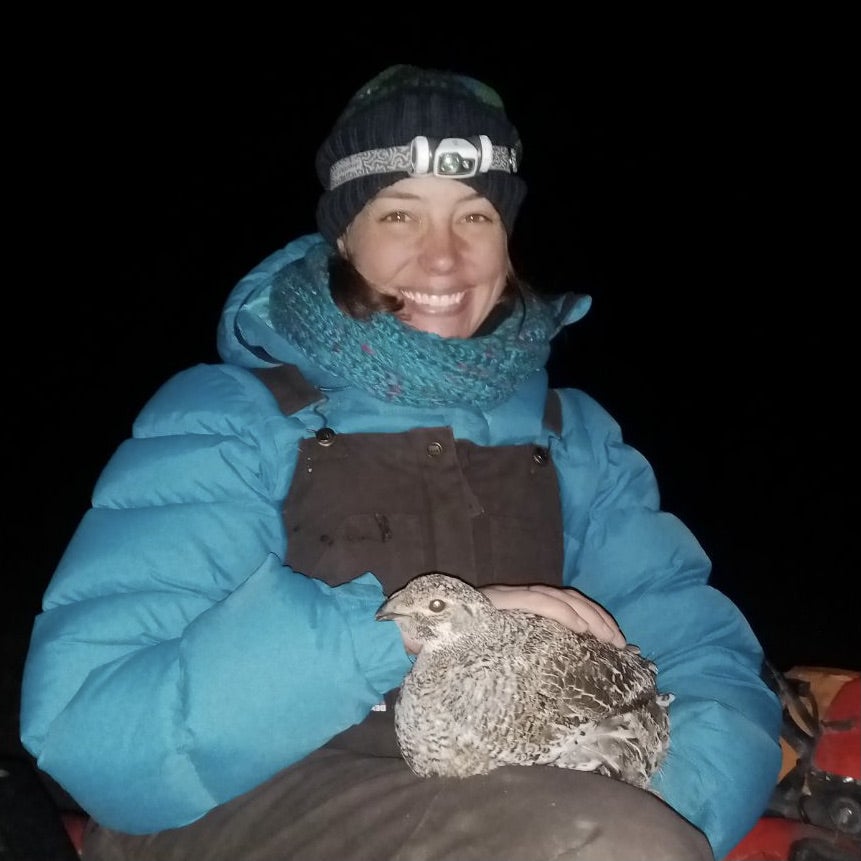 Stephanie Galla holding a bird in the field