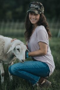 Maddi nealing next to a sheep