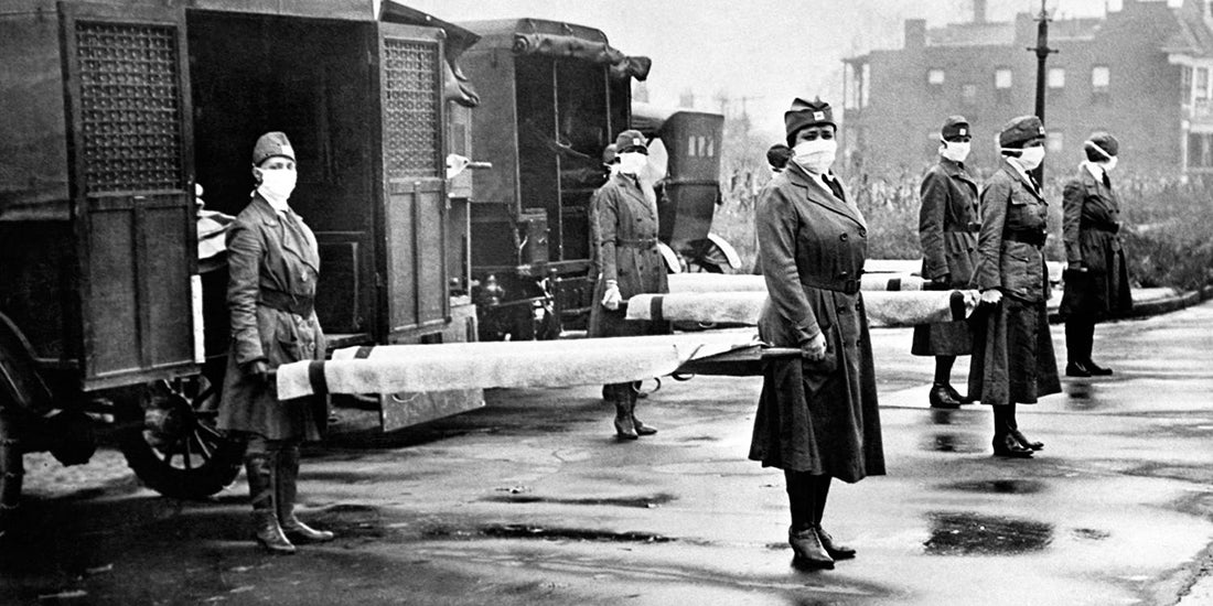 Nurses hold stretchers in front of ambulances
