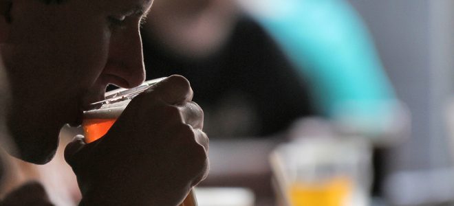 person drinking a beer from a glass
