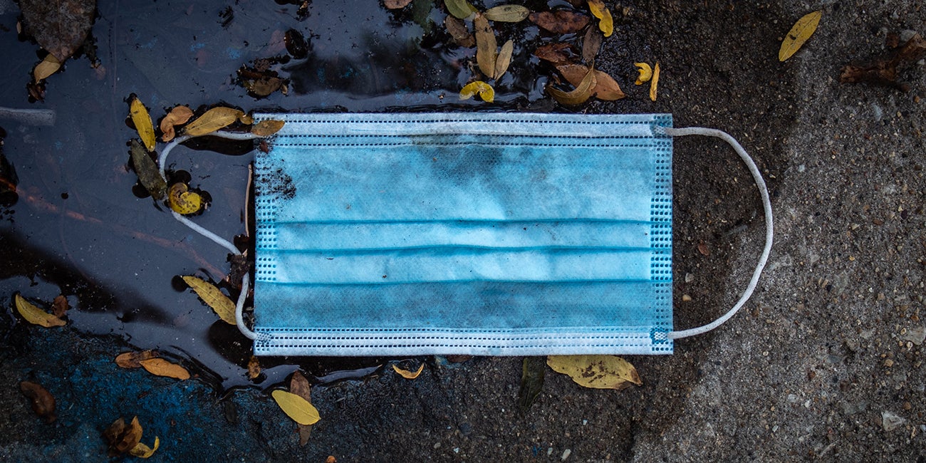 disposable mask on the ground in a puddle