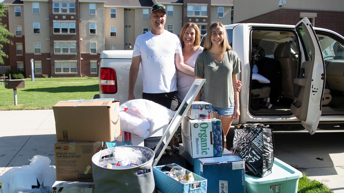 Parents and their daughter unload belongings on move-in day.