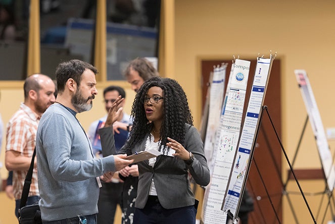 Two people looking at a poster and talking