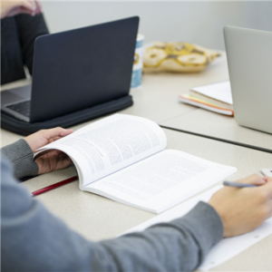 A student reading a textbook and taking notes