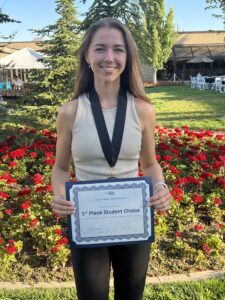 Photo of Lauren Snider holding her certificate for INBRE 1st place Student Choice awar