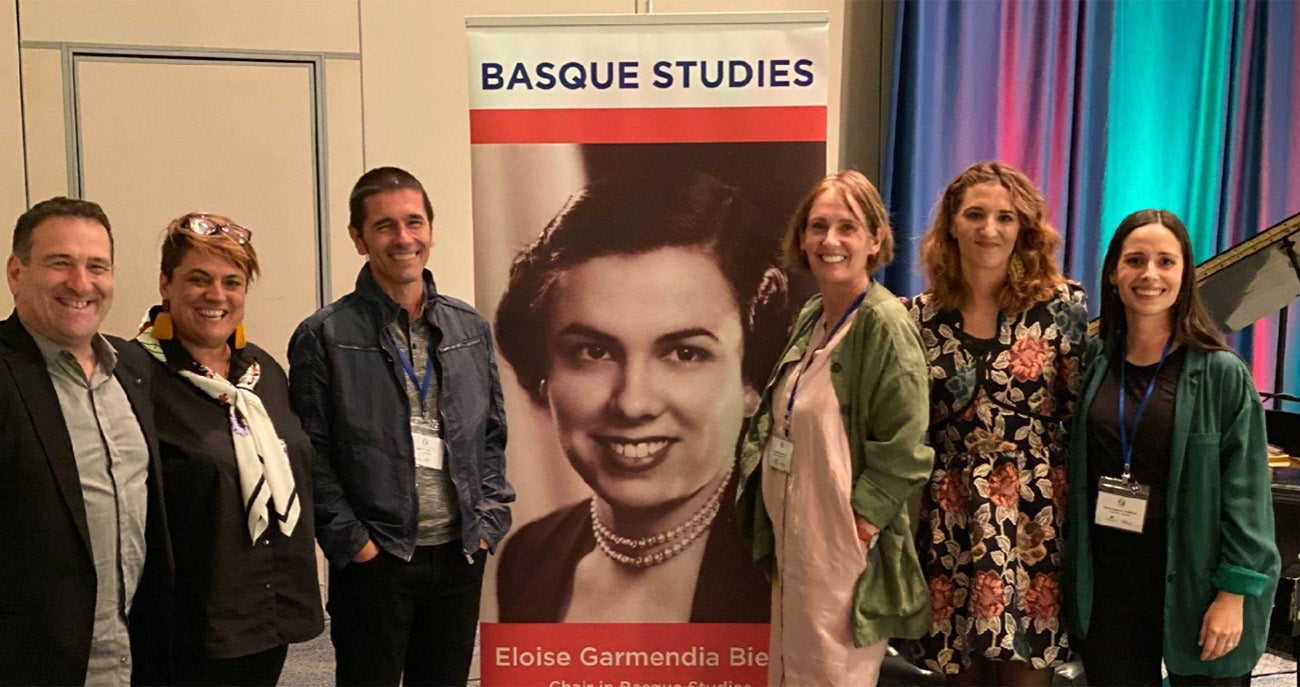 Group stands next to Basque studies banner