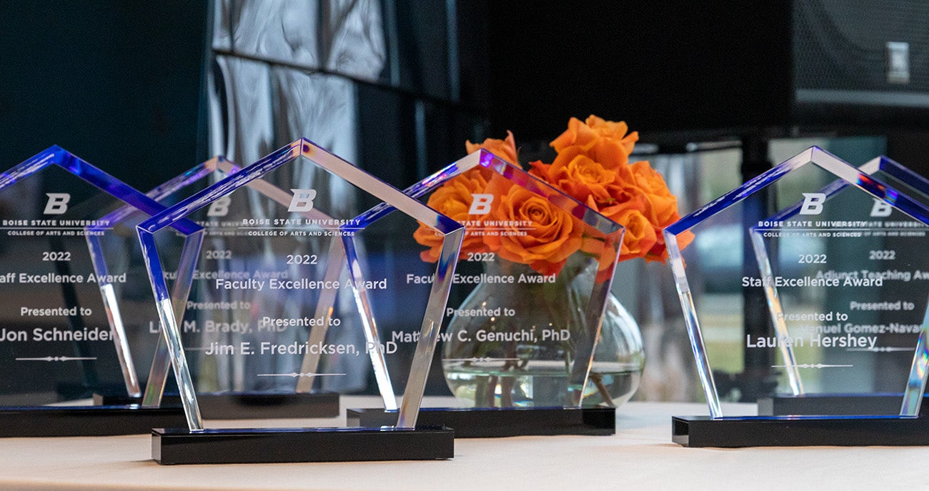 Etched glass awards with the words faculty and staff excellence with roses behind them
