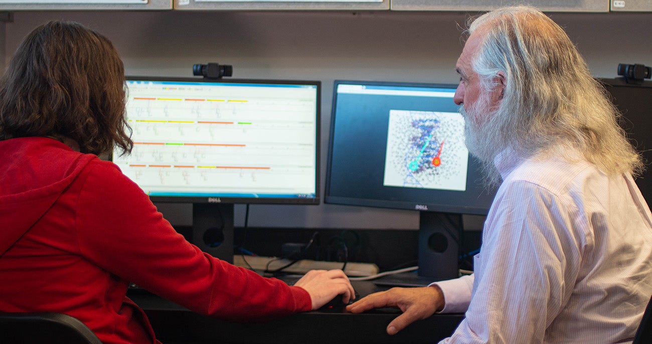 Greg Hampikian (right) and a student look at genetic data on a computer screen. Photo by Zeke Hopkins.