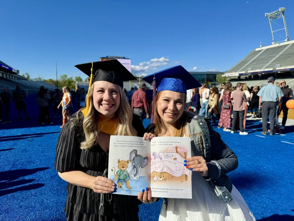 McKenzie Bell and Krista Hamel proudly hold open their children’s book