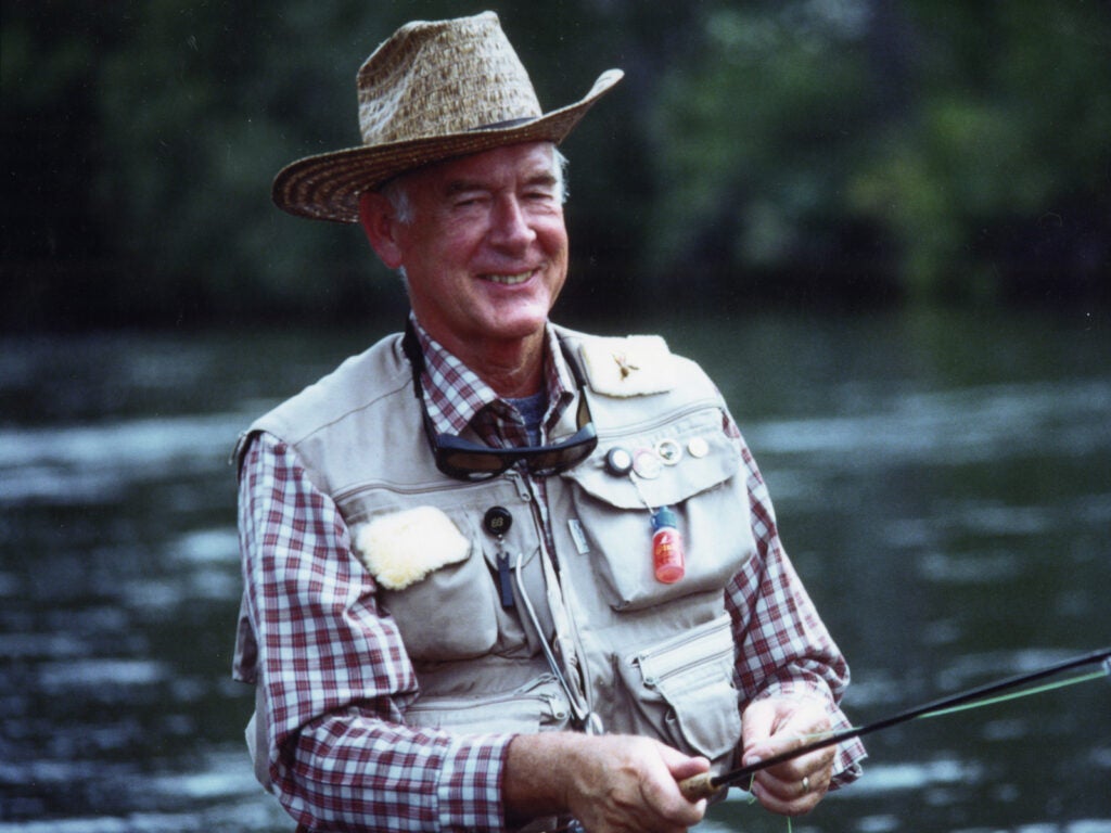 Governor Cecil D. Andrus fishing outdoors in a river.