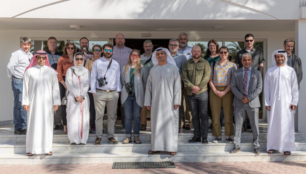 A group of scientists pose in front of a building.