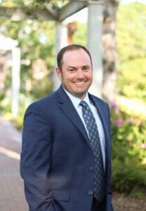 Adam Golden - headshot of man in blue suit