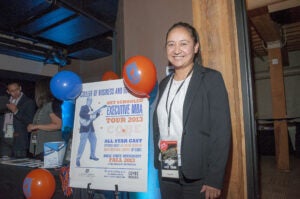 Student in front of EMBA poster -Get Schooled
