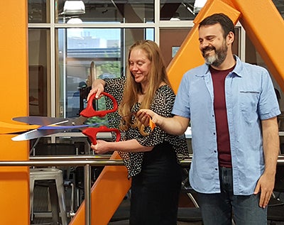 student cutting the ribbon for new program