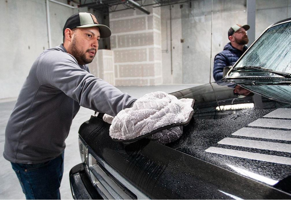 Gabe Garcia, with The Rag Company, wipes down the hood of a pickup truck