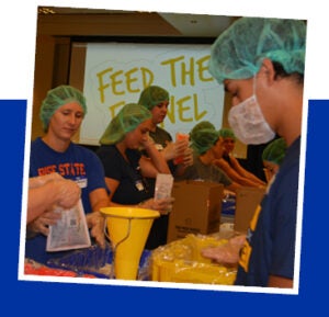 volunteers packing meals at feed the funnel