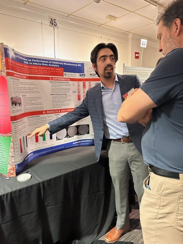 Kyle Holloway stands next to a presentation poster