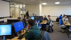 students sitting at computer workstations in a classroom