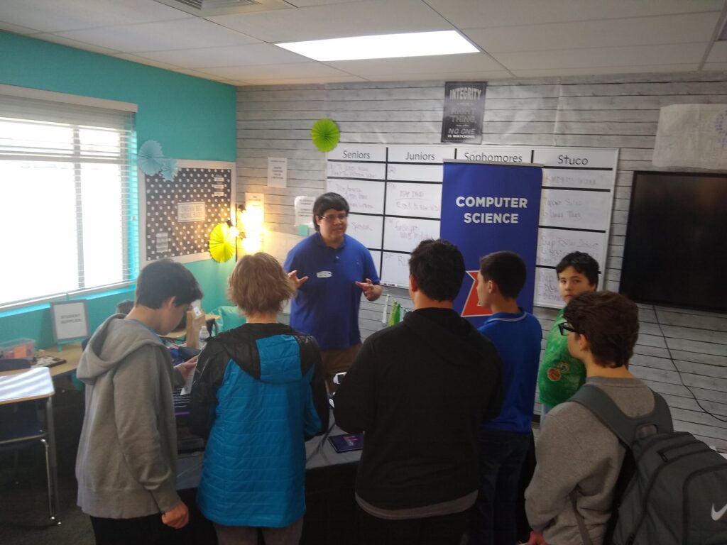 Computer Science student talking to junior high students