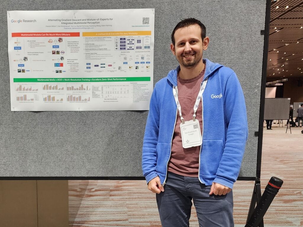 Photo of Dan Kondratyuk standing to the right of a Google Research poster titled "Alternating Gradient Descent and Mixture-of-Experts for integrated Multimodal Perception."