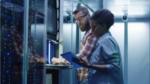 man at computer and woman with paper