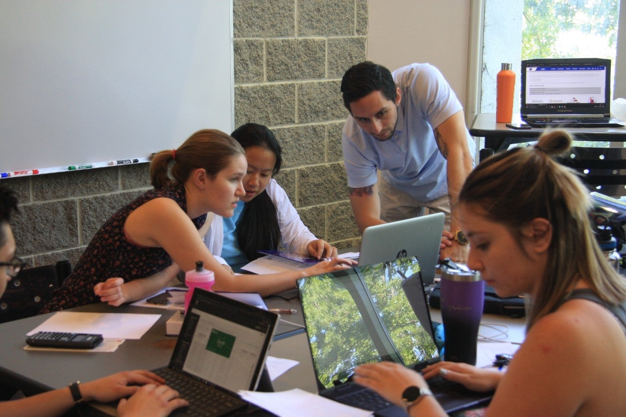 students with laptops studying together