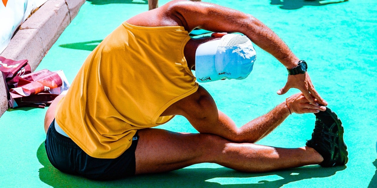 man-wearing-yellow-tank-top-and-black-shorts-stretching
