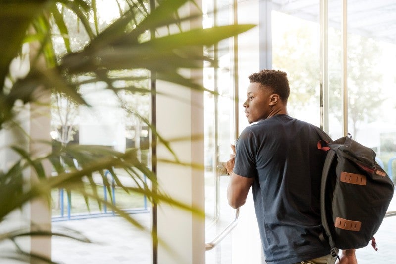 young black man going through a glass door