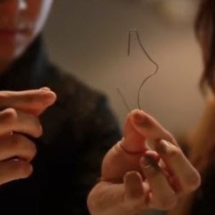 student holding bent wire