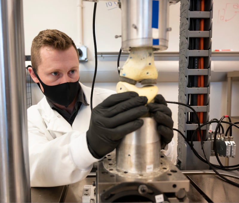 Graduate student using testing equipment on joint