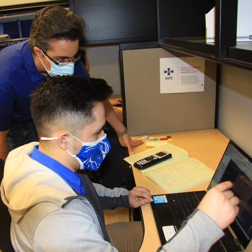 Student and professor looking at laptop screen