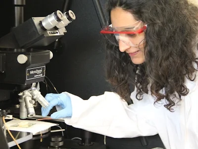 A woman in a lab with a microscope