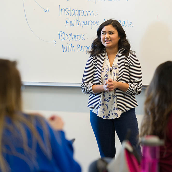 Speaker stands in front of class